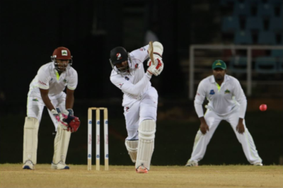 West Indies Cricket Board, 3 players on a field, one in mid swing.