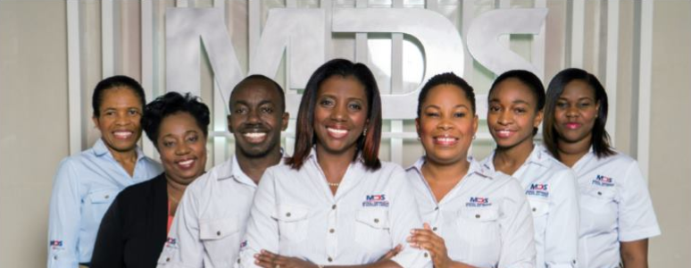 Medical Disposables & Supplies Limited, employees stand in front of their company abbreviation, MDS, for a group photo.