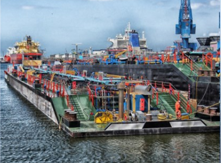 A large ship next to another ship. It looks industrial purposed.