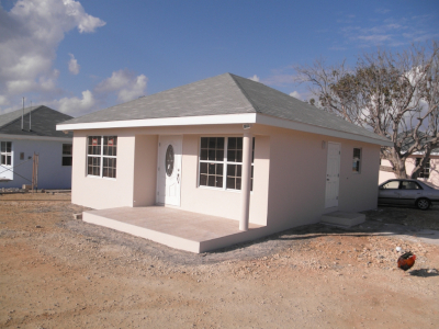 National Housing Development Trust, new home on a lot without grass. Blue sky with clouds in the background.