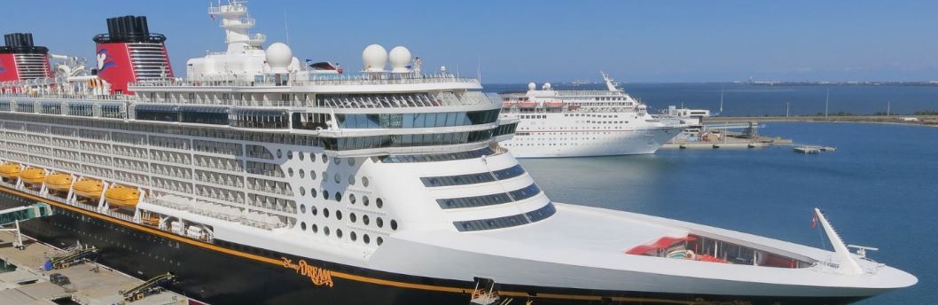 Disney cruise ship docked at port.