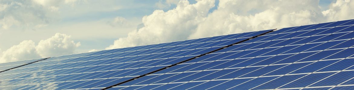Solar panels with clouds and sky above/behind. Blue Economy Strategy to drive energy transformation in the Caribbean.