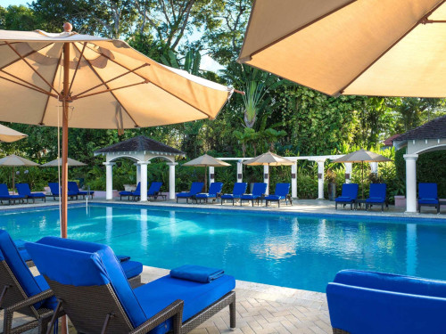 Fairmont Royal Pavillion pool with blue cushioned lounge chairs and umbrellas.