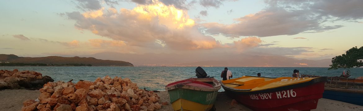 Jamaica Stock Exchange. Beach view with a couple boats pulled up on the sand
