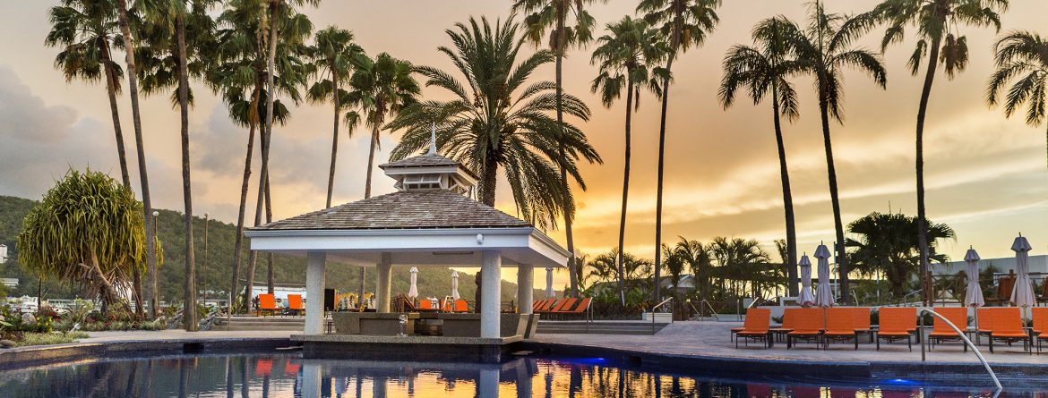 Moon Palace Jamaica pool at sunset with palm trees and orange sky.